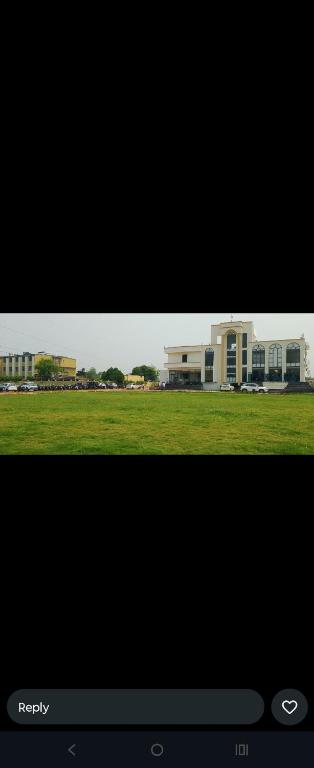a view of a building and a field of grass at Raja Krishna Mahal in Kushinagar