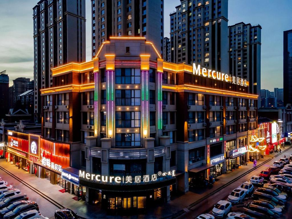 a metropolis building with cars parked in a parking lot at Mercure Huhhot Economic Zone in Hohhot