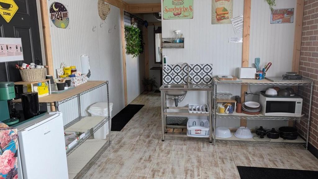 a room with a kitchen with shelves and a microwave at Geraldton Rooms Unit D in Geraldton
