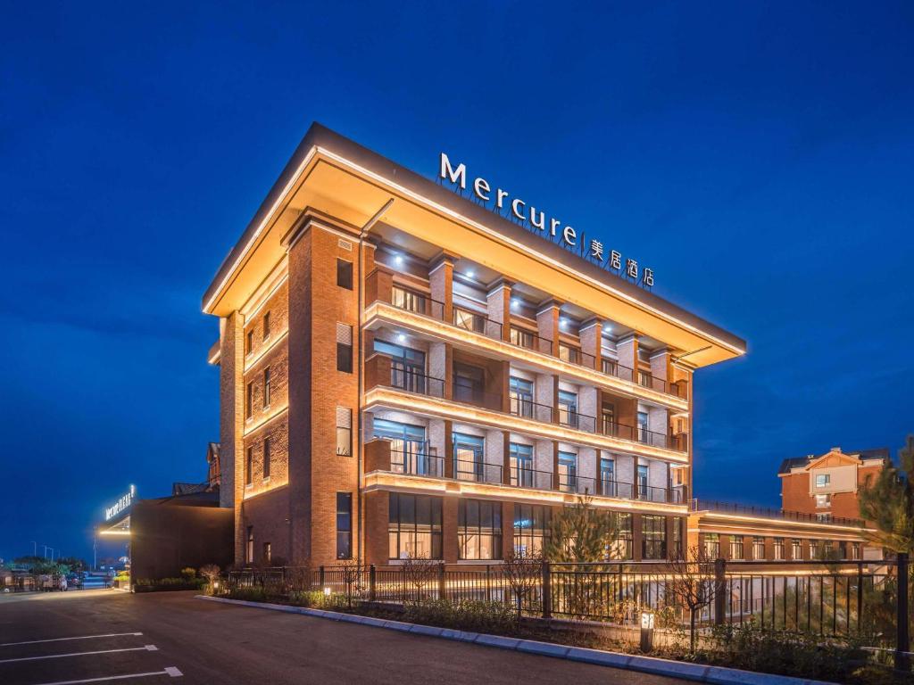 a building with a sign on the side of it at Mercure Changbai Mountain North in Antu