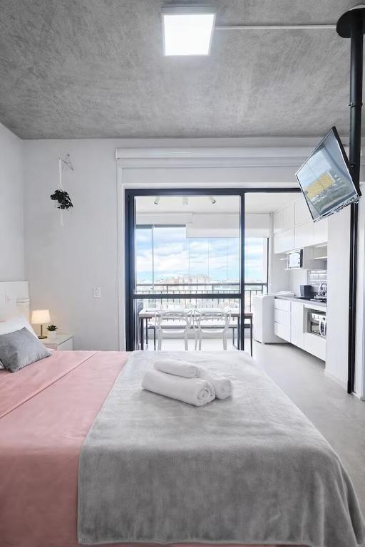 a bedroom with a bed with a view of the ocean at Studio Aurora, Bom Retiro - Anhembi - Com garagem in São Paulo
