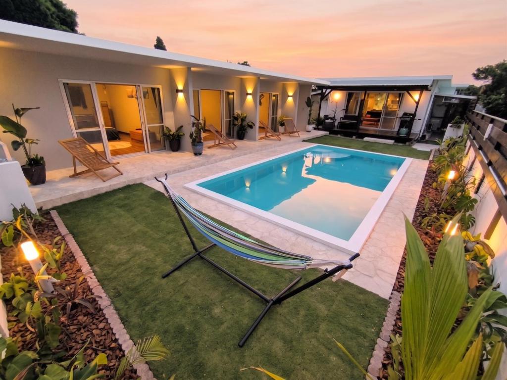 a backyard with a swimming pool and a chair at Shiraho Breeze Poolside Villa in Ishigaki Island
