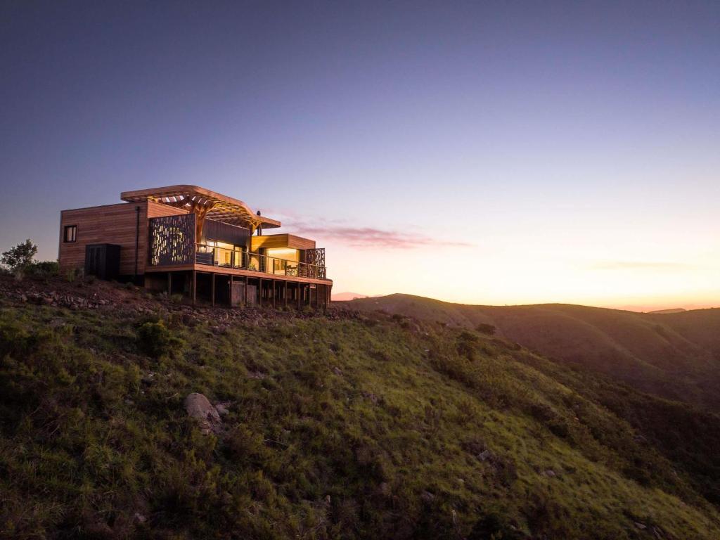 a house on top of a hill with the sun setting at Mantis Hiddn in Addo in Addo