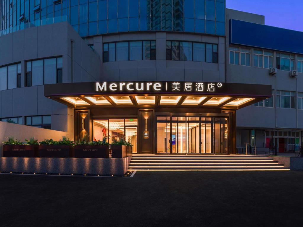 a building with a sign on the front of it at Mercure Qingdao Coast in Qingdao