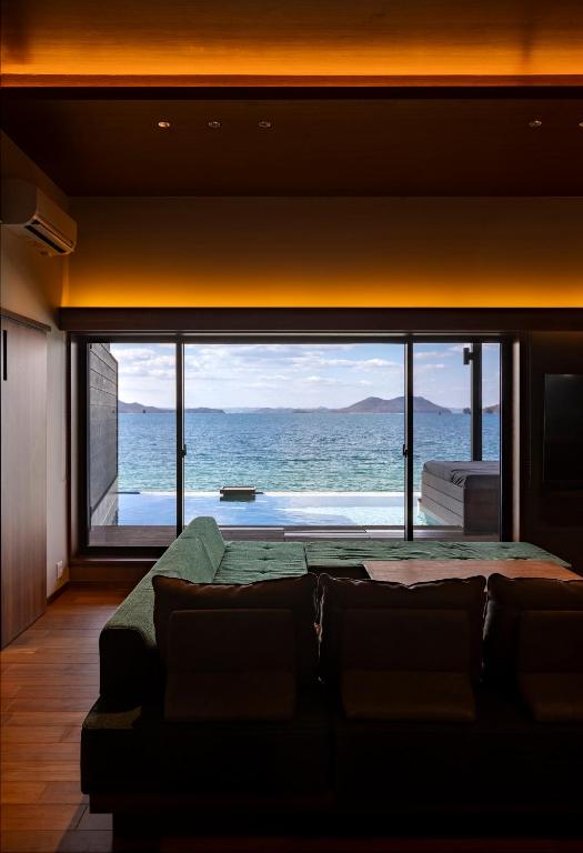 a room with a large window with a view of the ocean at Sunset SPA Resort AJI by SETO CLAS in Takamatsu