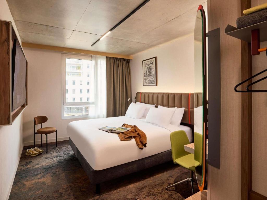 a hotel room with a large bed and a window at You Hotel Amiens - Handwritten Collection in Amiens