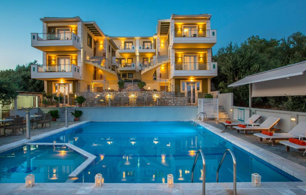 a hotel with a swimming pool in front of a building at Orizontas Residencies in Kastrosikia