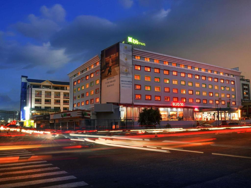 a building on a street at night with traffic at IBIS STYLES KINSHASA in Kinshasa