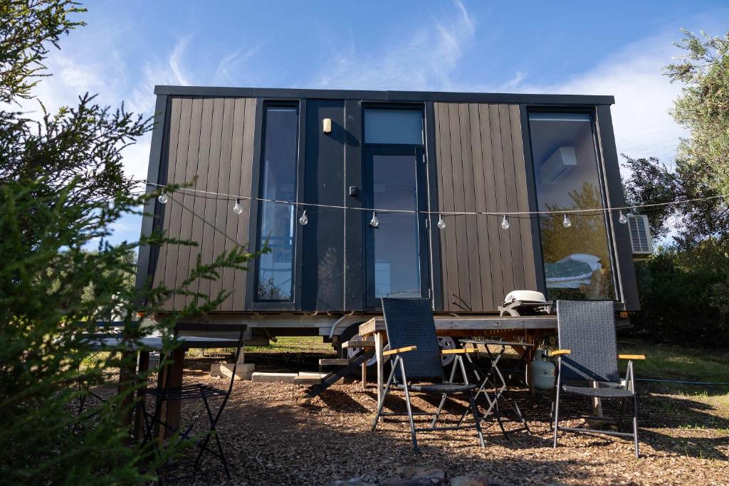 a tiny house with a table and chairs at Scrub Tiny House by Tiny Away in McLaren Vale