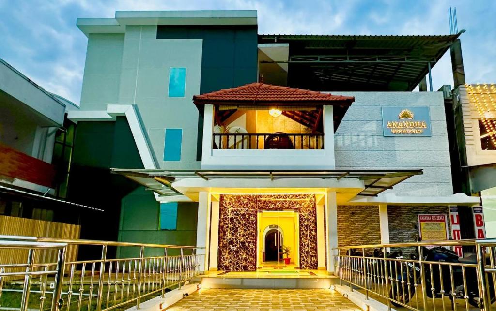 a building with a yellow door and a balcony at ANANDHA RESIDENCY in Karaikal