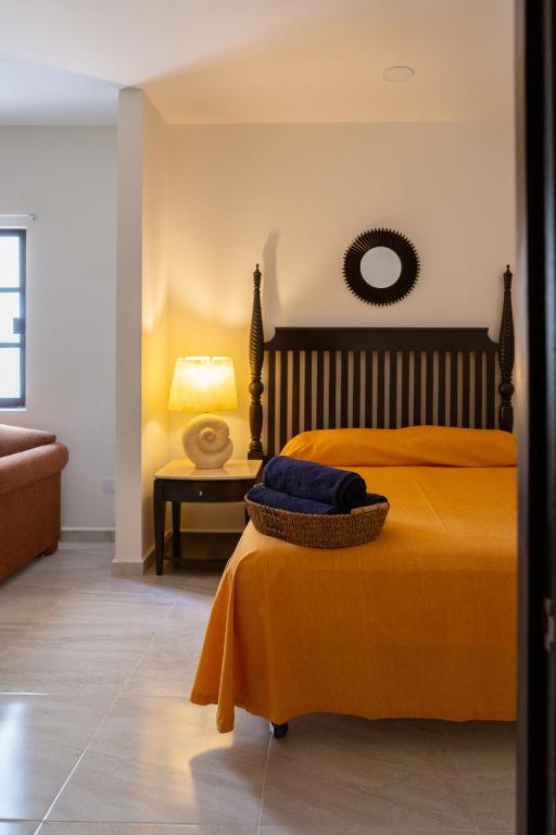 a bedroom with a bed and a table with a lamp at Saules Armonía in Cancún