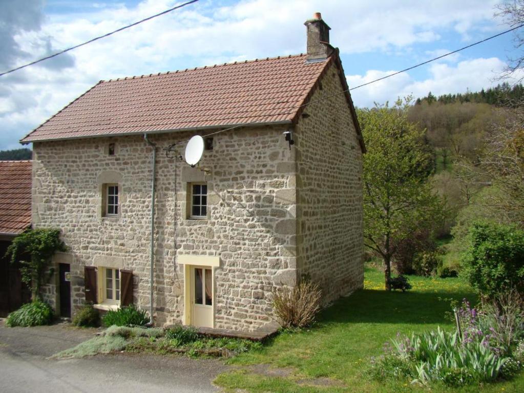 an old stone house with a red roof at La bachellerie in Nedde