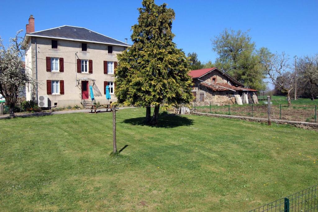 a tree in the middle of a yard in front of a house at Naugeat in La Roudie