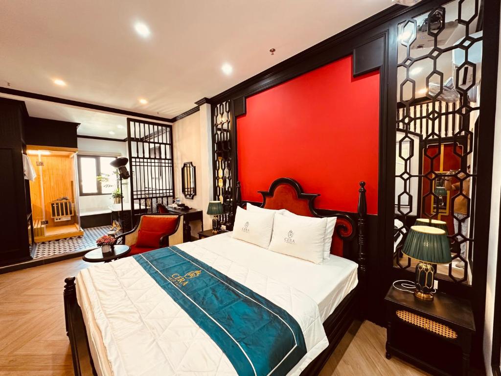 a bedroom with a bed and a red wall at Cera Hotel in Ho Chi Minh City