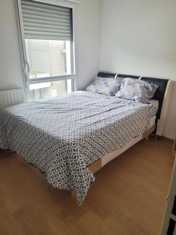 a bed sitting in a bedroom with a window at Repos chez l habitant in Rennes