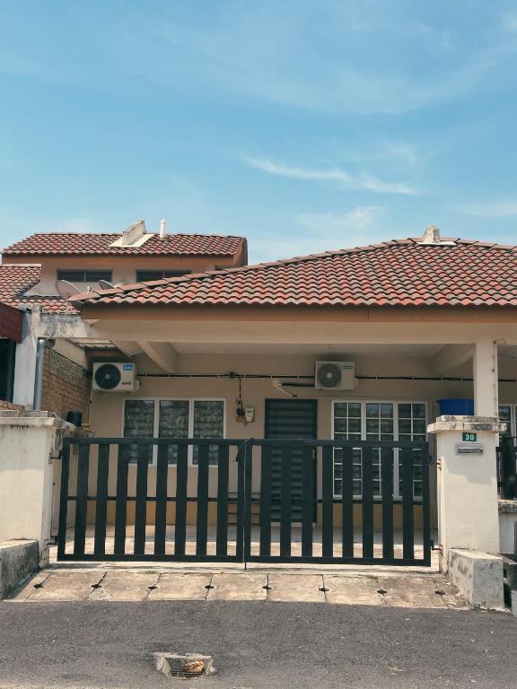 a house with a gate in front of it at Teratak Raya in Tanjung Rambutan
