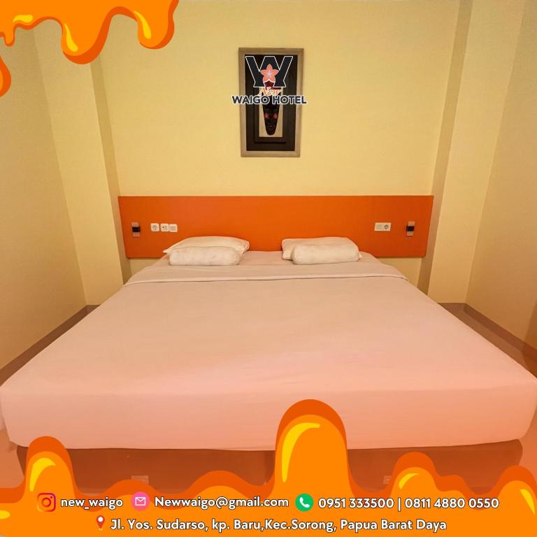 a bedroom with a large bed with two pillows at New Waigo Hotel in Sorong