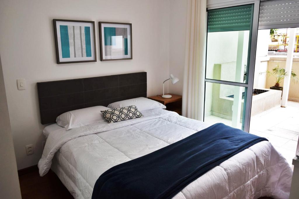 um quarto com uma cama grande com duas almofadas em Giardino Villa Paulista apartaments em São Paulo