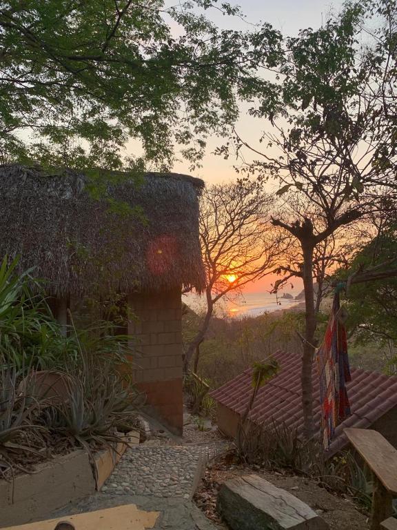 a house with the sunset in the background at Las lemurias in Mazunte