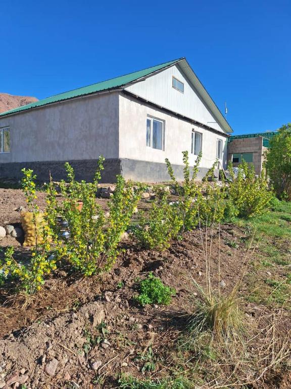 a house on a hill with plants in front of it at Miyar Farmhouse in Ak-Say