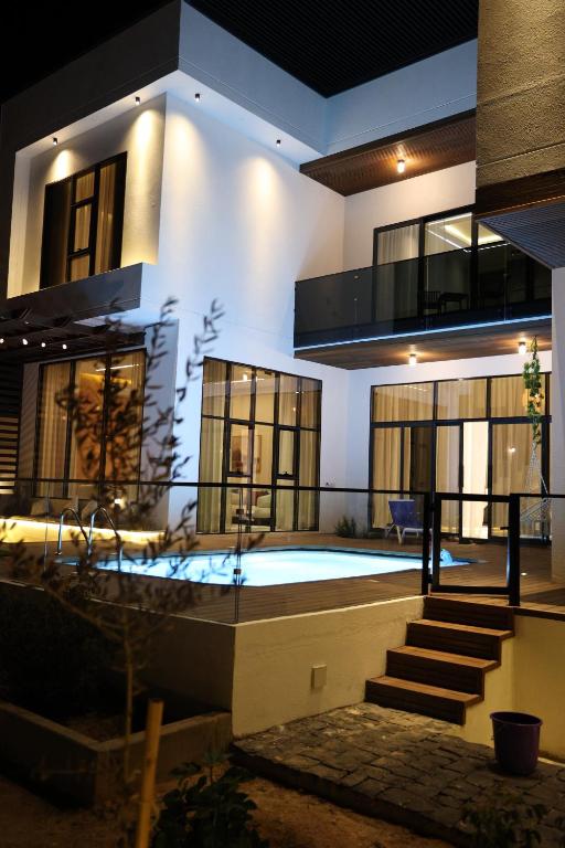 a house with a swimming pool in front of it at إستراحة نمارق in Al ‘Aqar