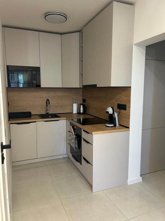a kitchen with white cabinets and a sink at Apartmán JT in Vyšné Opátske