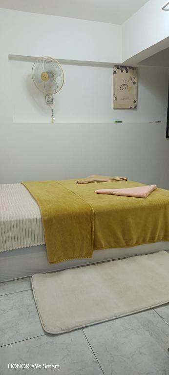a bedroom with two beds and a fan on the wall at Hot Spring Residential B in Kuala Lumpur