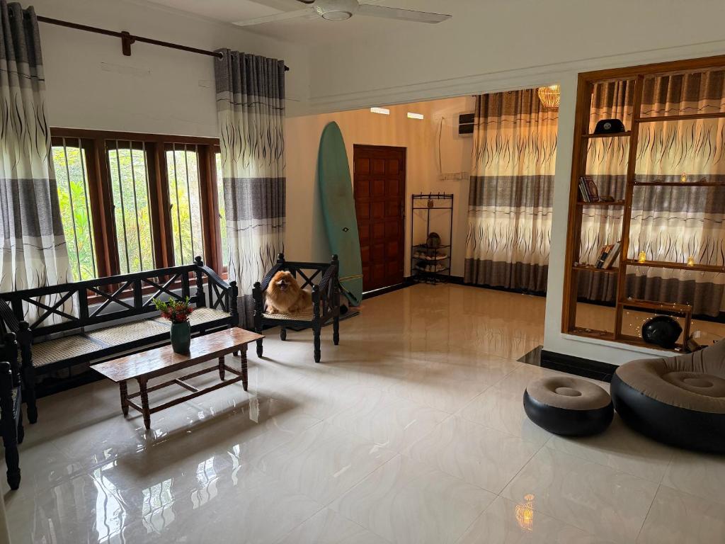 a living room with a surfboard on the wall at Fisherspot Villa in Weligama