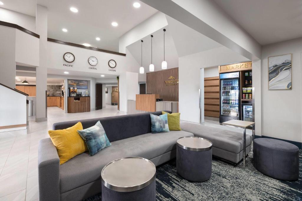 a living room with a couch and two stools at Wingate by Wyndham Myrtle Beach At Outlets in Myrtle Beach