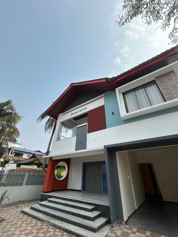 a house with a red door and stairs in front at The Lavish Landmark in Jorhat