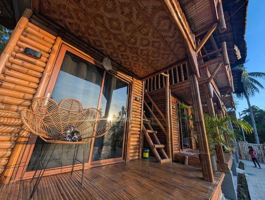 a wooden porch with wicker chairs on a house at Jadens Guesthouse in Siquijor