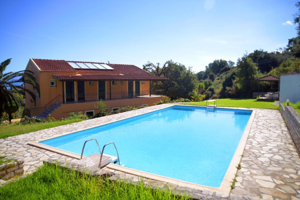 a swimming pool in front of a house at krystallia apartments in Dassia