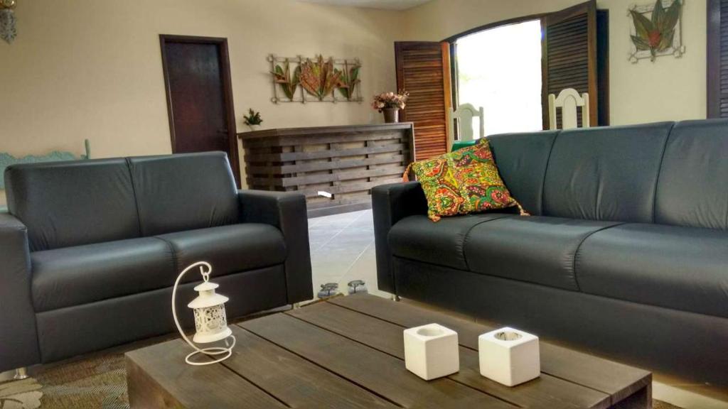 a living room with two couches and a coffee table at Le Monde Hostel - Suites e Camas in Angra dos Reis