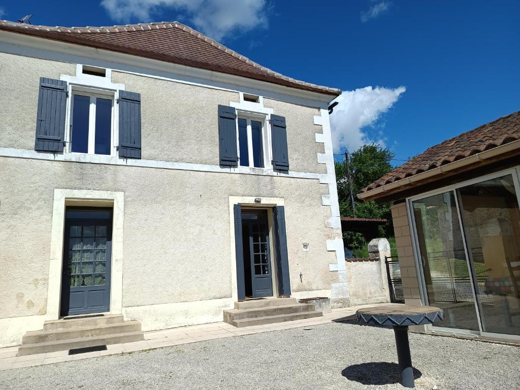a house with a bench in front of it at Gîte des deux Moulins en Périgord Vert in Grand Brassac