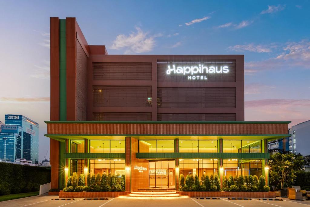 a large building with a sign on it at Happihaus Hotel Bangkok in Bangkok
