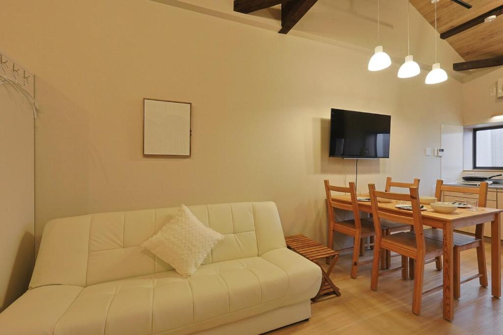 a living room with a white couch and a table at Bonju Abikomichi in Osaka