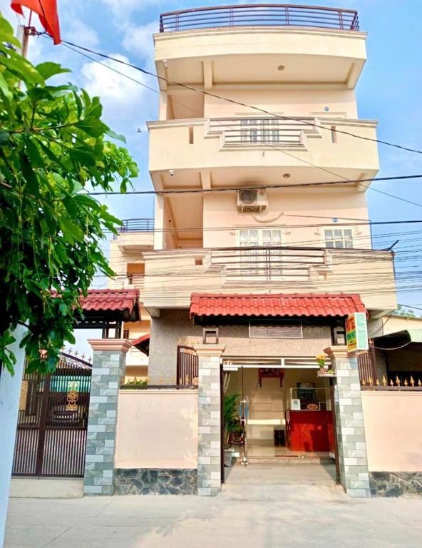 a building with a tower with a red awning at Hotel Minh Phát in Công Thanh