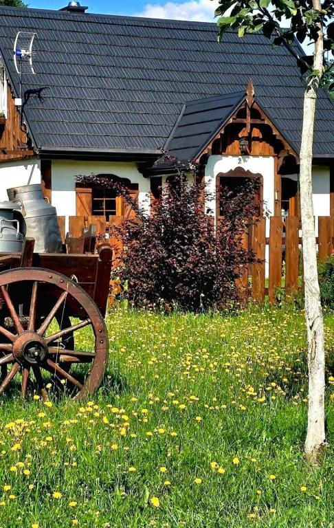 an old cart sitting in the grass in front of a house at Casa Del Campo 1 in Gaśno