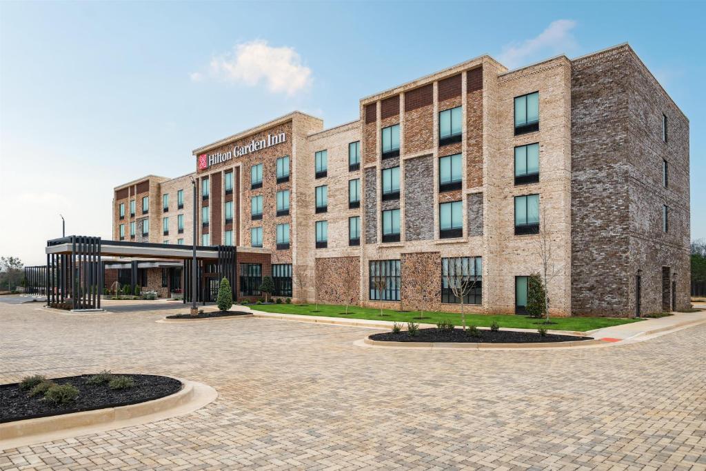 a large brick building with a courtyard in front of it at Hilton Garden Inn Perry in Perry