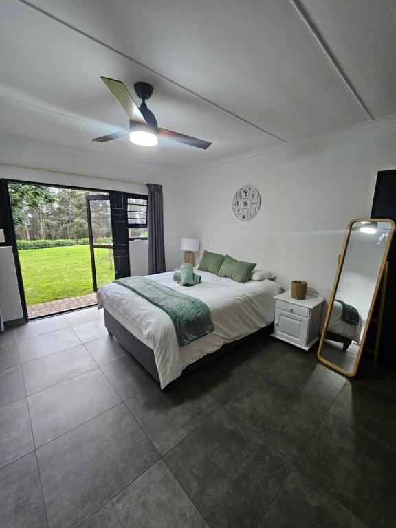 a bedroom with a bed and a ceiling fan at Little Oasis in Hilton