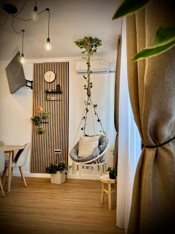 a room with a swing with plants and a table at VerdeViu Apartments 3 Thermalis Residence Sânmartin Oradea Băile Felix 1 in Sînmartin