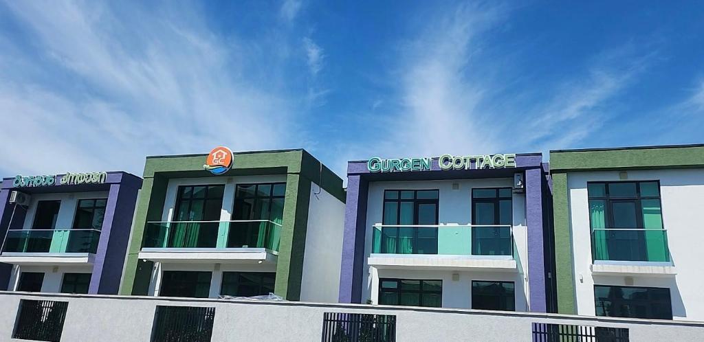 a building with a green shuttle sign on top of it at Gurgen Cottage in Ureki