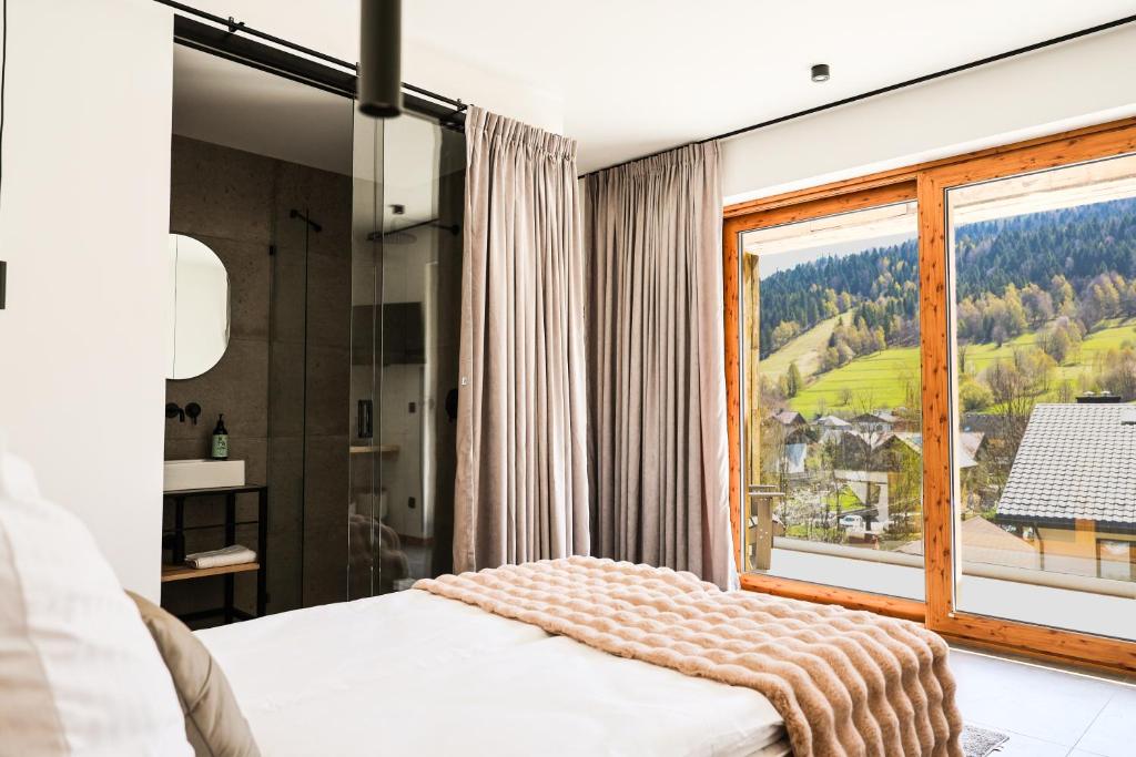 a bedroom with a large window with a mountain view at Wierzbowa16 in Szczyrk