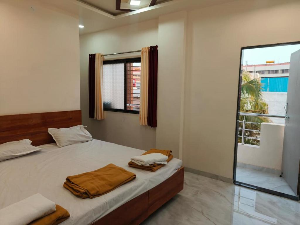 a bedroom with a bed with two towels on it at HOTEL Shiv Sai in Shirdi
