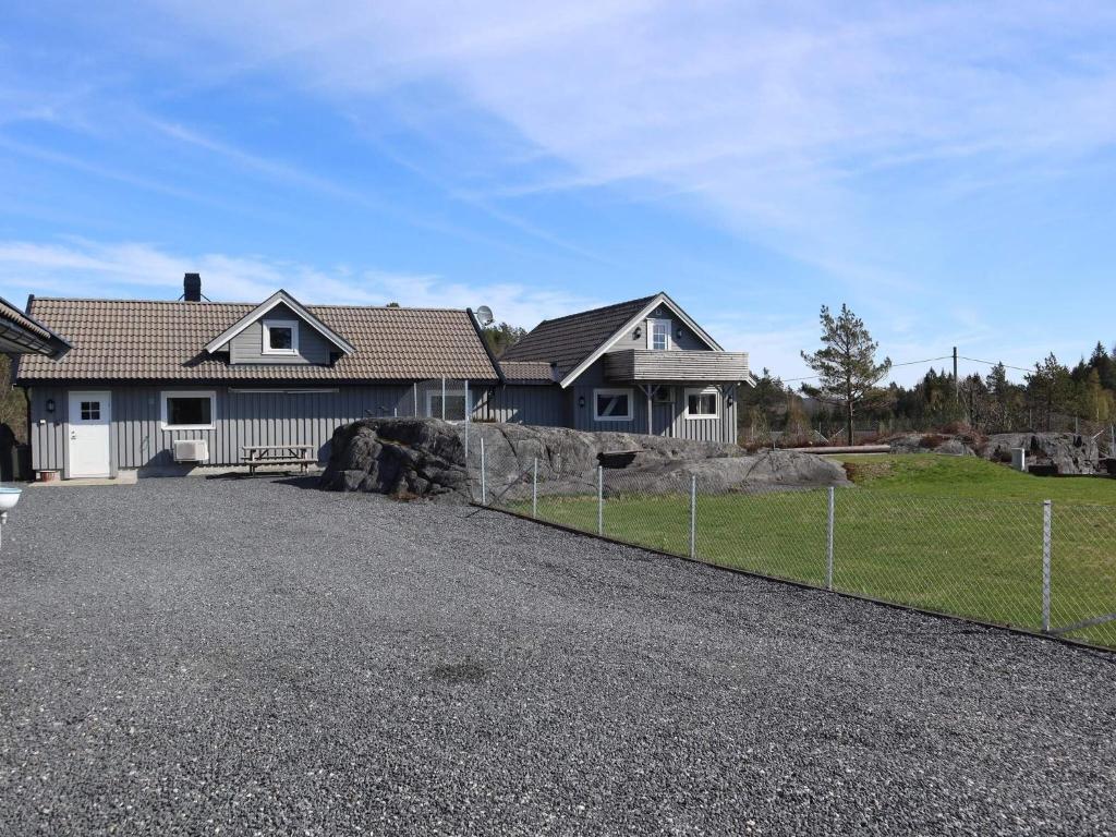 a house with a fence in front of a driveway at 7 person holiday home in Risør in Risør