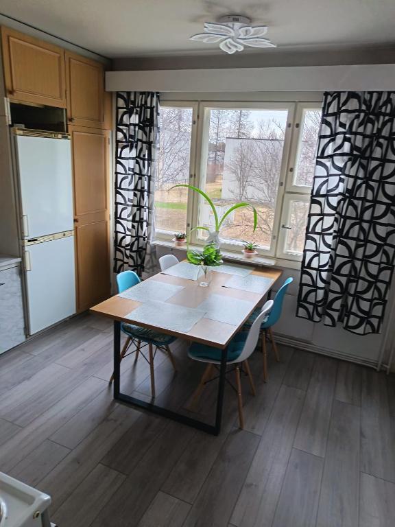 a kitchen with a table and chairs in a room at Siisti valoisa kolmio in Lieksa