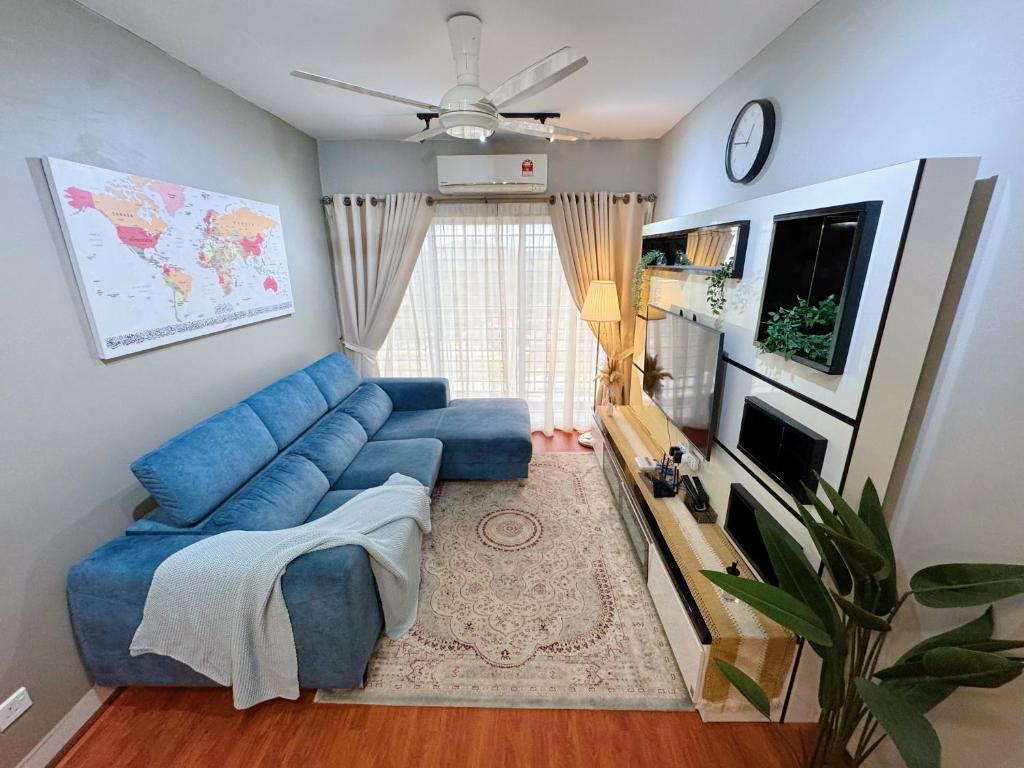 a living room with a blue couch and a tv at D'Camellia 43500 Semenyih Homestay in Semenyih