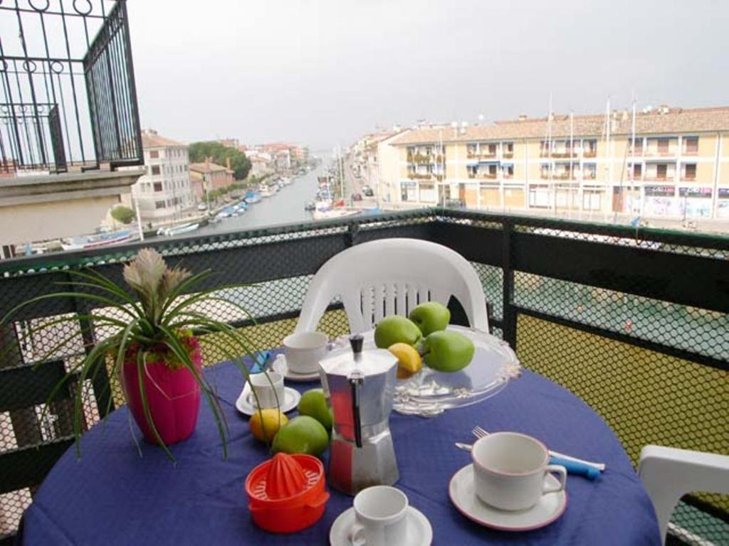einen Tisch mit einem blauen Tischtuch und Obst auf dem Balkon in der Unterkunft Riviera Appartament in Grado