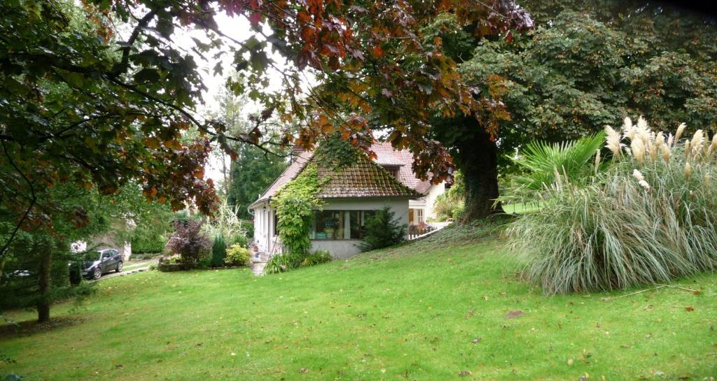 una casa en una colina de hierba con un árbol en Le Clos de Marenla, en Marenla