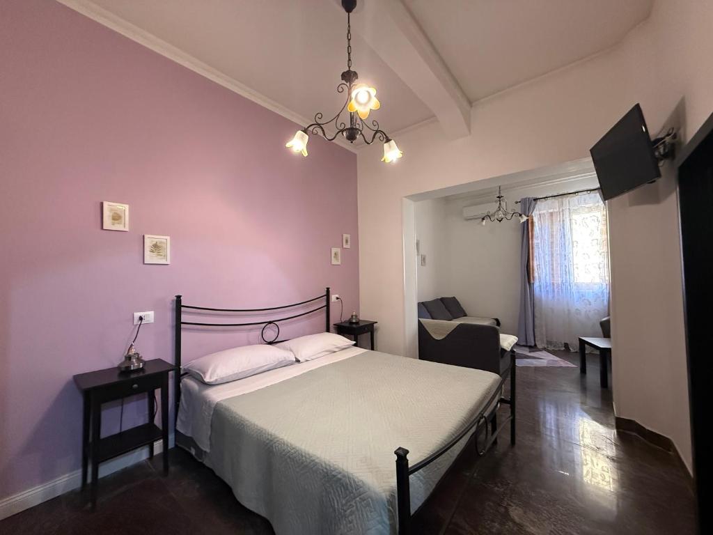 a bedroom with a bed with white sheets and a chandelier at LightHouse - Casa di Luce in Reggio di Calabria